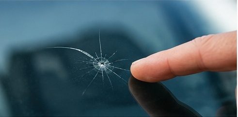 Replacement windshield being set into a vehicle opening
